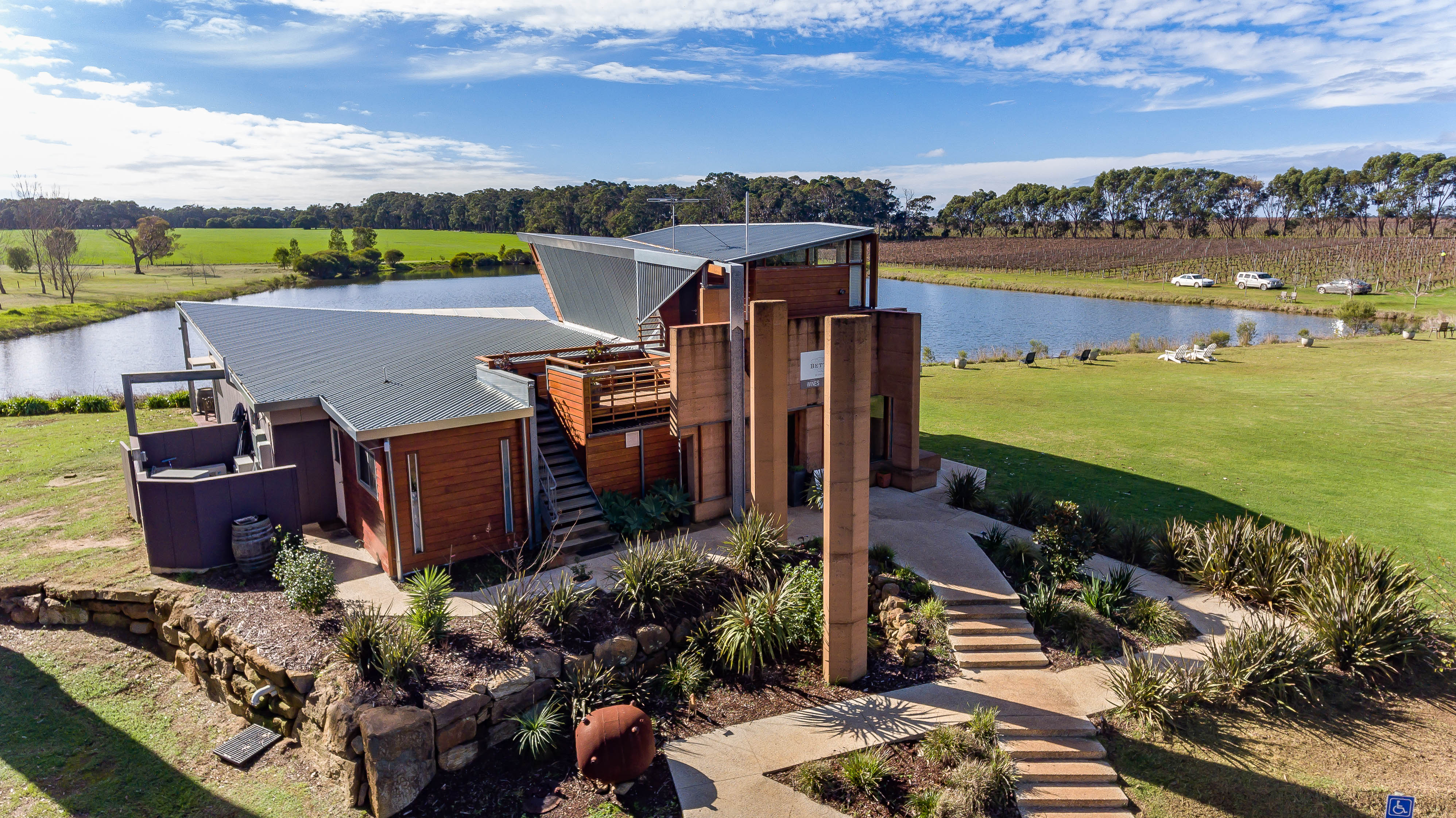 Bettenay Wines  building with vineyard and lake 